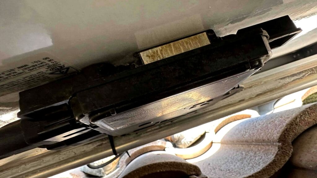 lose-up view of a non-reporting microinverter installed under a solar panel