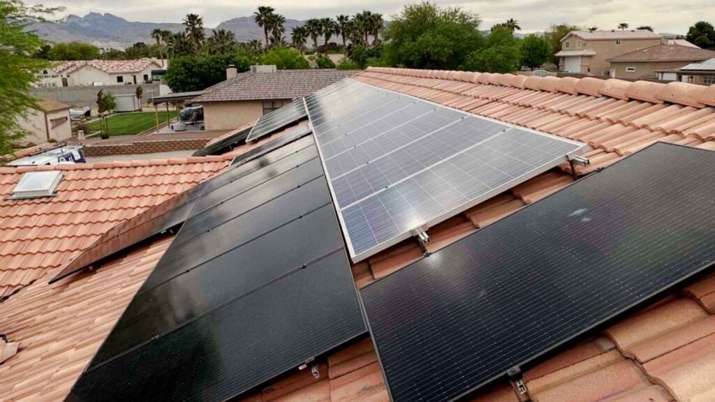 A tile‑roof installation in Las Vegas featuring a mix of black and silver photovoltaic panels mounted at optimal tilt with mountain views in the background.
