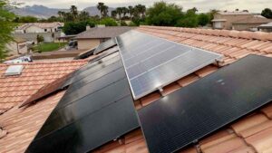A tile‑roof installation in Las Vegas featuring a mix of black and silver photovoltaic panels mounted at optimal tilt with mountain views in the background.